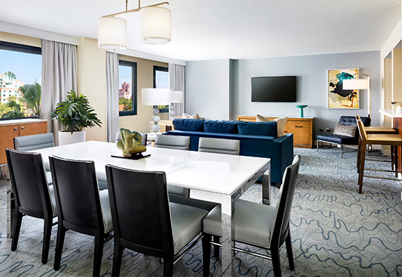 Dolphin Grand Suite Parlor with Tables, Couch, Chairs and Large TV